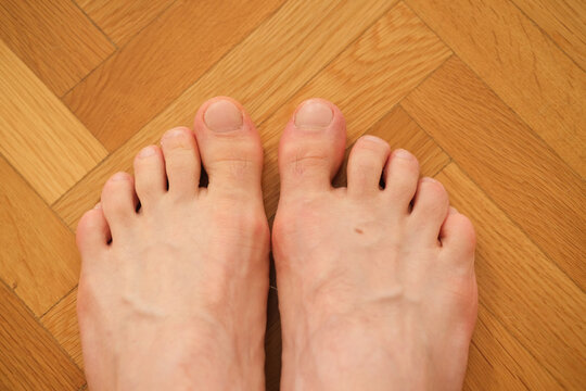 Bare feet on wooden floor photographed close up for home comfort and relaxation, natural skin tones and warm lighting