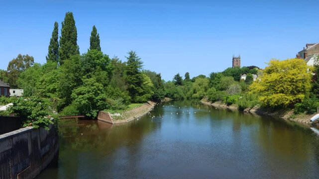 The River Exe flowing through the small Devon town of Tiverton with St Paul's Anglican church