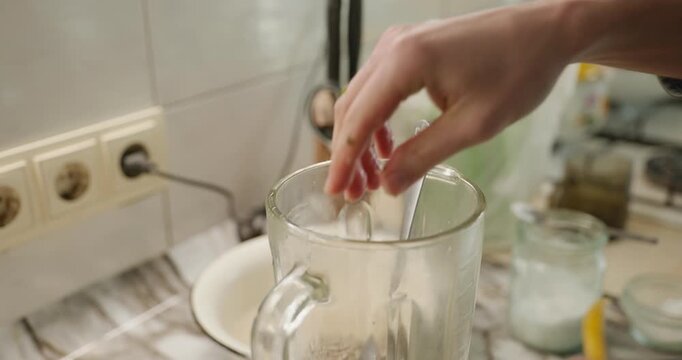 Male hand squeeze lemon juice in blender. Man prepare food cook at kitchen at home. 4K 10-bit