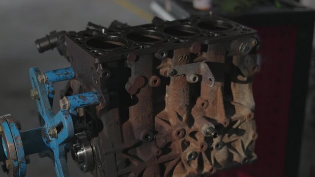 Vintage combustion engine component in a mechanics workshop.Coroded metal cylinder block during car maintenance service.