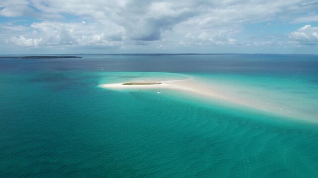 Aerial view of Pelican Bank white sandbar surrounded by turquoise waters under a cloudy sky, K'gari, Hervey Bay, Queensland, Australia.