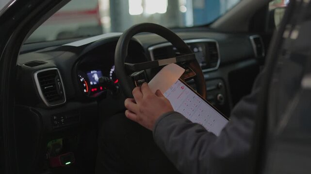 The dashboard and internal electronics are carefully tested by an experienced garage electrician.The mechanic connects a wireless OBD2 scanner to the vehicle's electronic control unit to read error .