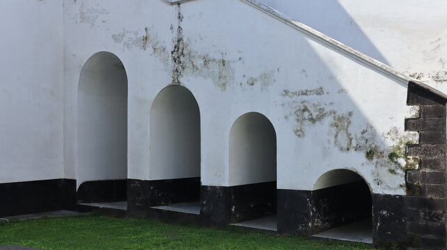 Beautiful arched doorways are located beneath the staircase attached to the wall of the perimeter structure.