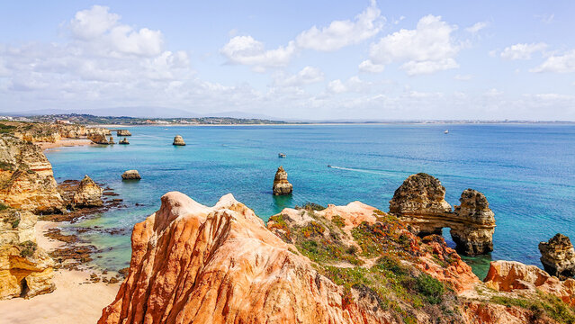 Golden limestone cliffs and rock arch panorama at Ponta da Piedade, Lagos