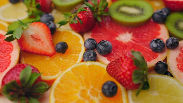 Background of fresh fruits and berries rotating. Vegan sweet food, flat lay.
