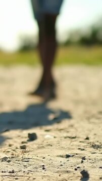 Vertical video: Kicking barefoot man juggling incoming soccer ball on sand, pal in shorts playing