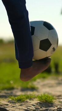 Vertical video: Rolling barefoot player navy pants after call training with soccer ball at park