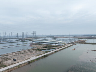 Fototapeta premium Aerial view of energy storage power station with high voltage transmission towers and industrial facilities
