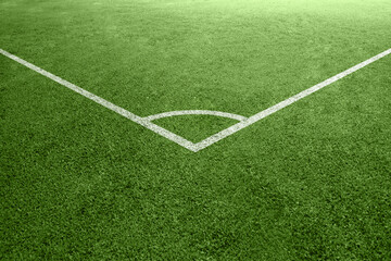 Obraz premium Close-up view of a corner kick area on a green soccer pitch with white painted lines on synthetic grass turf