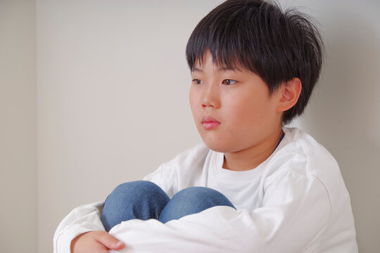 無表情の中につらさをにじませる男の子