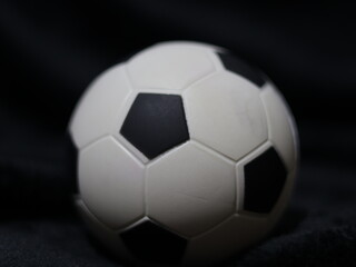 Una toma de cerca de una pelota o balón de fútbol con luces en un fondo negro con algo de desenfoque  © Elika R