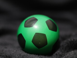 Una toma de cerca de una pelota o balón de fútbol con luces en un fondo negro con algo de desenfoque  © Elika R