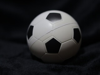 Una toma de cerca de una pelota o balón de fútbol con luces en un fondo negro con algo de desenfoque  © Elika R