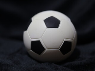 Una toma de cerca de una pelota o balón de fútbol con luces en un fondo negro con algo de desenfoque  © Elika R