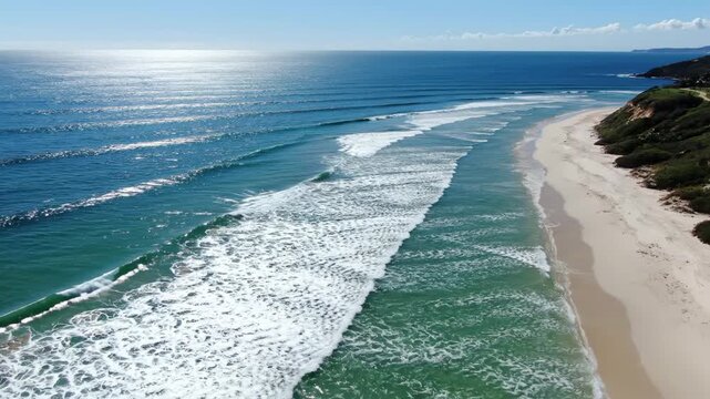 An awe-inspiring aerial perspective captures the dynamic interplay of a vast azure ocean meeting a pristine golden shoreline, with gentle turquoise waves gracefully embracing the sandy expanse