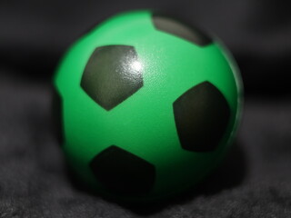 Una toma de cerca de una pelota o balón de fútbol con luces en un fondo negro con algo de desenfoque  © Elika R