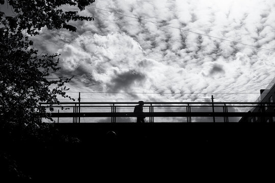 Silhouette on a Bridge Beneath a Dramatic Sky