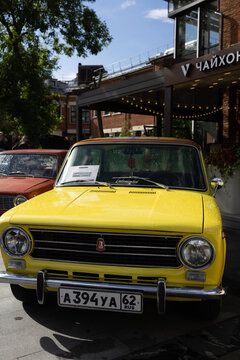 Classic soviet vintage cars lada vaz 2101 on city street exhibition near cafe under blue sky