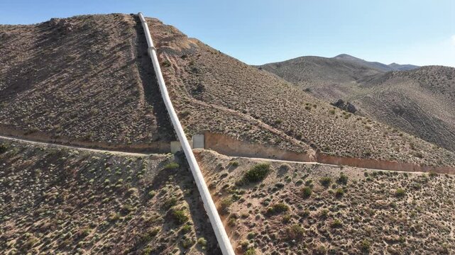 Aerial shot of the Los Angeles Aqueduct as it passes over some low mountains in California. The aqueduct supplies water to Los Angeles and Southern California.