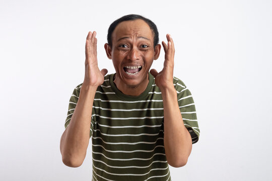 Negative human emotions and feelings. Angry annoyed bearded adult man screams loudly, expresses irritation, gestures angrily, keeps palms raised, reproaches someone and has quarrel 