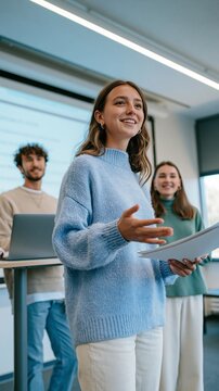 Jeune femme souriante pr&eacute;sentant un projet en r&eacute;union d'entreprise