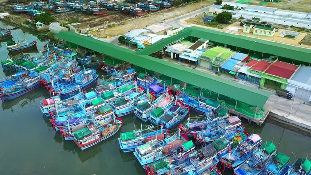 Ca Na Bay in Ninh Thuan, Vietnam viewed from above at noon in summer with hundreds of fishing boats moored and fishing villages below.
