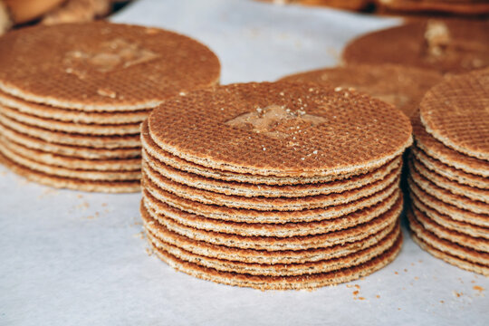 Freshly baked Dutch stroopwafels stacked in neat piles, showcasing crisp waffle texture and caramel-filled layers, ideal for bakery, dessert and traditional snack concepts
