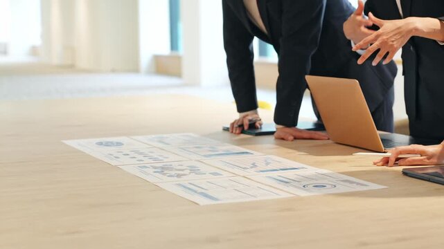 A group of business people having a meeting while looking at documents in the office.