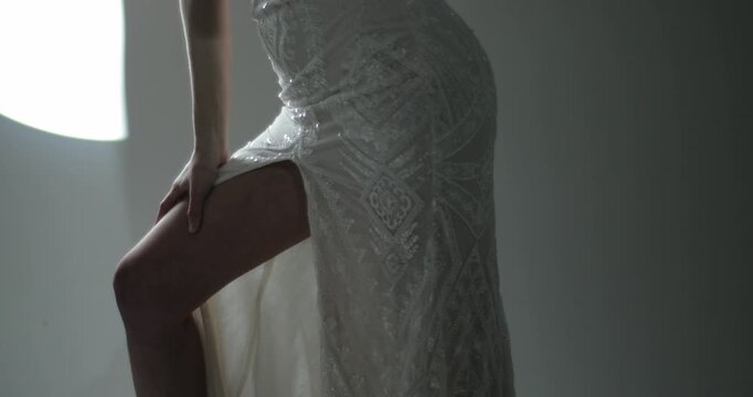 Cinematic close-up of slim female figure in fitted lace wedding dress with soft studio light in background. Perfect for bridal, fashion, luxury, and wedding content.