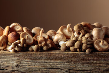 Obraz premium Fresh shiitake, champignon, and shimeji mushrooms on an old wooden table.