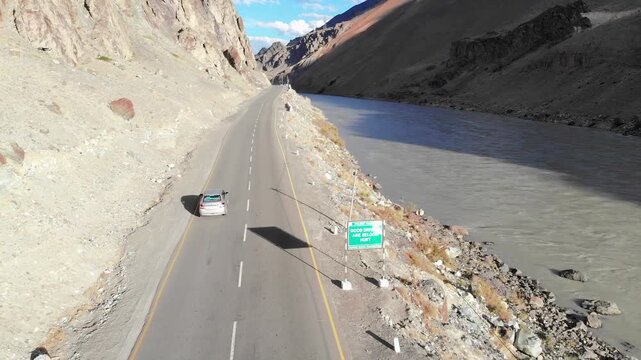 Road trip adventure: Drone follows car on remote Ladakh Himalayan highway and Indus River.