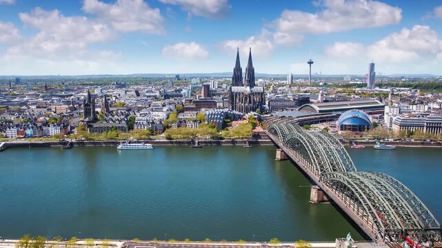 Elevated time lapse view of the cityscape of Cologne, Germany, with river Rhine, Cathedral and old town houses at the riverfront during a sunny summer day