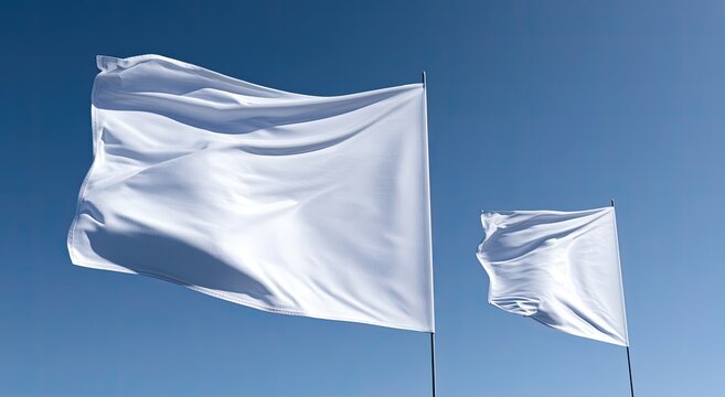Two blank white flags ripple and flutter against a clear blue sky