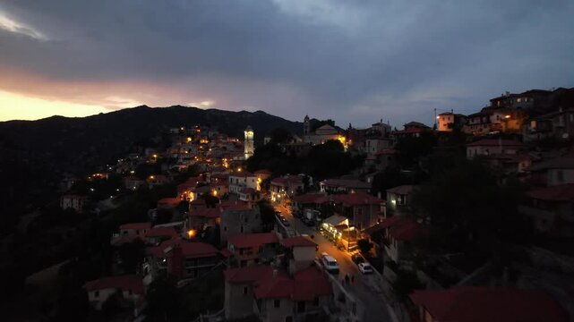 Aerial establishing shot of mountain village at twilight in Greece