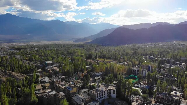 Drone rising over Leh town revealing majestic Himalayan mountains.