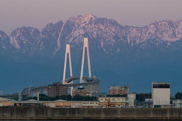 新湊大橋と夕日に染まる剱岳 © easterlily.photos
