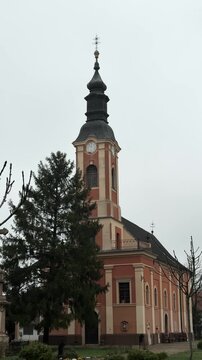 Historic church rises above the streets of Senta with its distinctive bell tower and clock. Architectural landmark representing faith, heritage, culture and tourism
