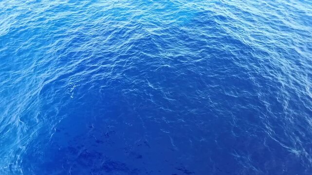 Aerial shot of ocean surface with sunlight creating a vibrant texture