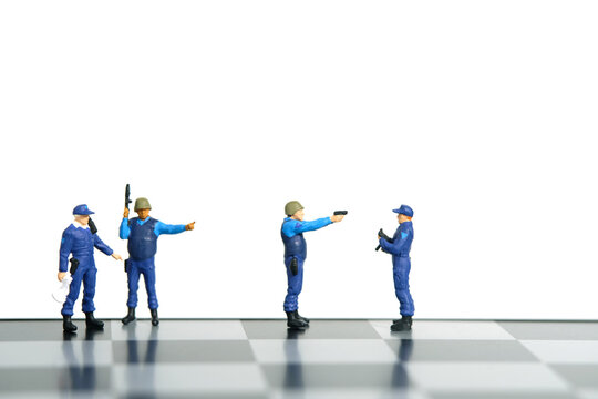 Miniature people toy figure photography. Protection strategy concept. A security officer standing above chessboard. Isolated on white background.