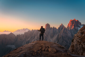 Obraz premium Hiker Admiring on Mountain Peak at Sunrise Overlooking Cadini di Misurina Dolomites Italy