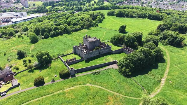 Majestic view of the historic medieval Craigmillar Castle in Edinburgh, Scotland. Beautiful stone fortress and museum architecture with ancient battlements and defensive walls, surrounded by lush gree