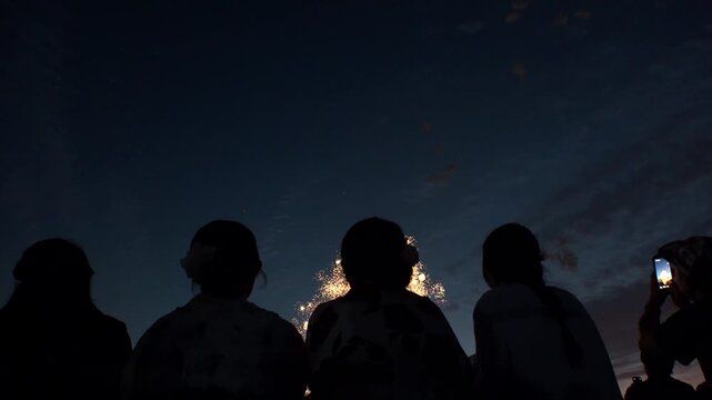 TOKYO, JAPAN - MAY 2026 : View of fireworks and back shot of people. Japanese summer season and festival concept video.