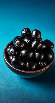 Fresh Jamun (Java Plum) Fruits in Wooden Bowl on Blue Background