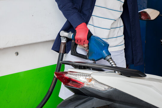 Close-up of hands filling gasoline into a motorcycle tank