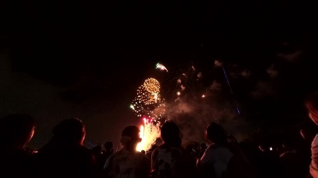 TOKYO, JAPAN - MAY 2026 : View of fireworks and back shot of people. Japanese summer season and festival concept video.