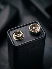 Obraz premium Square 9V battery terminal close up in a dark studio