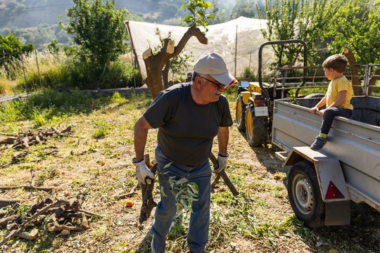 Grandfather teaching grandson about farming and hard work