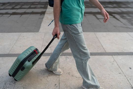 Gen z guy travels in Italy with trolley and backpack