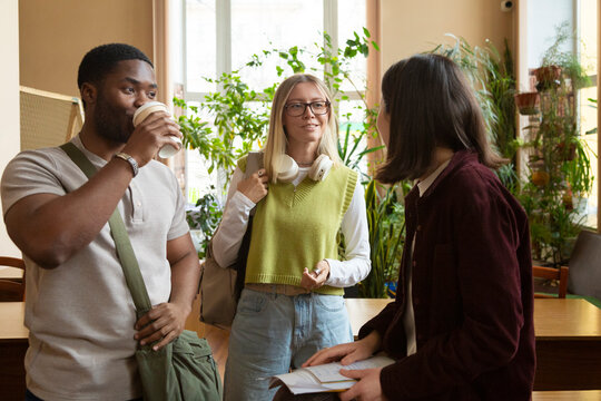 Diverse students conversing in college library setting