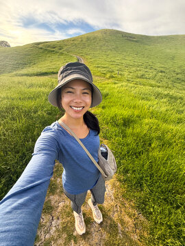 ugc selfie of asian hiker on hillside trail nature hike alone 